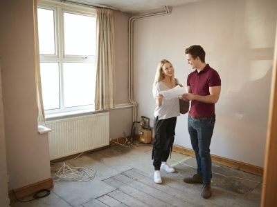 couple-buying-house-for-first-time-looking-at-house-survey-in-room-to-be-renovated.jpg